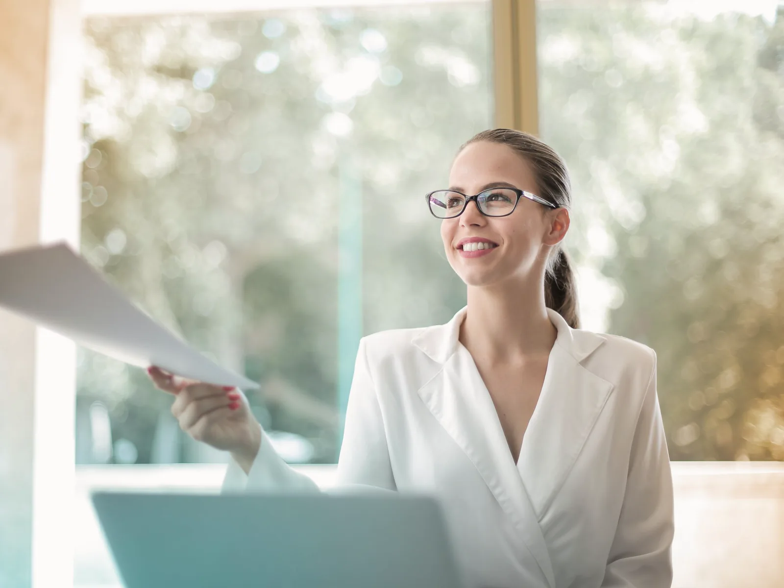 A smiling team member handing papers across her desk